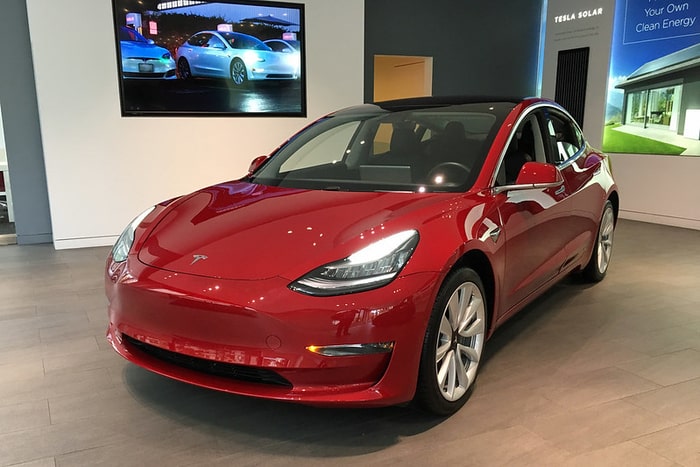 Czerwona Tesla Model 3 stojąca w salonie sprzedaży