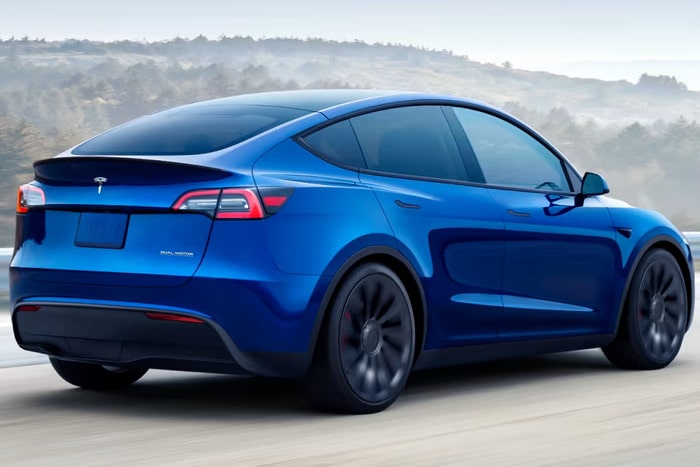 Niebieska Tesla Model Y w ruchu na drodze