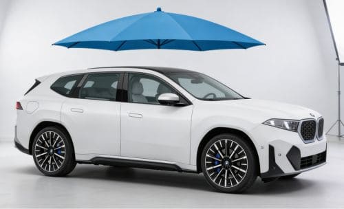 BMW iX3 pod parasolem ochronnym symbolizującym ubezpieczenie GAP
