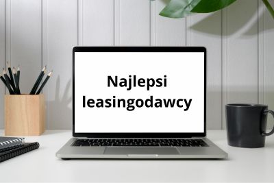 Laptop na biurku z napisem "Najlepsi leasingodawcy" na ekranie.