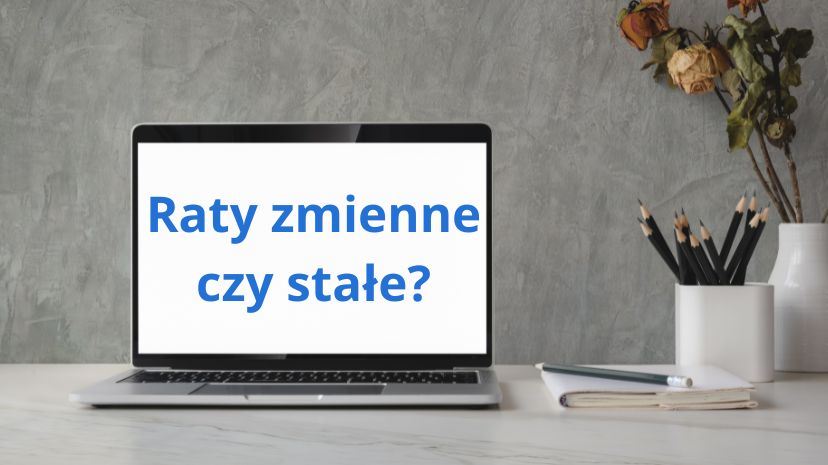 Otwrty i włączony laptop stojący na biurku z napisem Raty zmienne czy stałe?