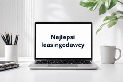 Laptop na biurku z napisem "Najlepsi leasingodawcy" na ekranie.